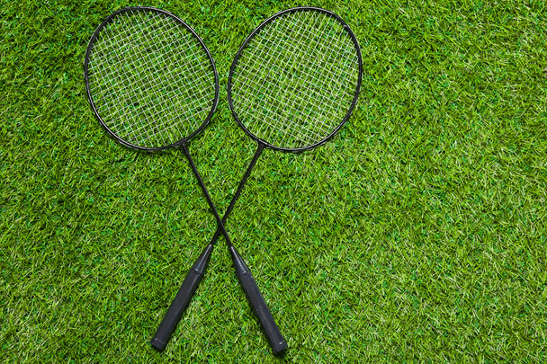 Two badminton rackets lying crossed on the grass - Photo, Image