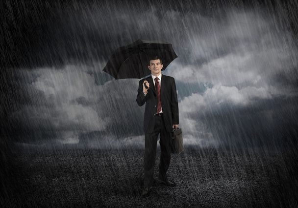 Young businessman with umbrella - Фото, зображення