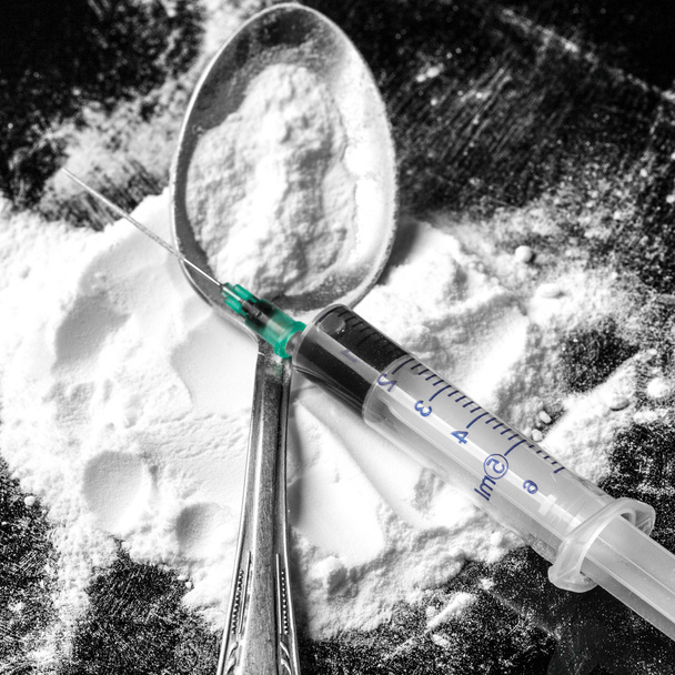 Drug syringe and cooked heroin on spoon - Photo, image