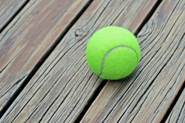 Bola de tênis em fundo de madeira
 - Foto, Imagem