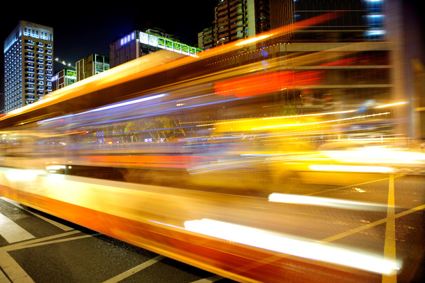 High speed and blurred bus light trails in downtown nightscape - Zdjęcie, obraz