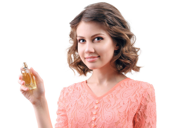 Beautiful woman with perfume bottle isolated on white - 写真・画像