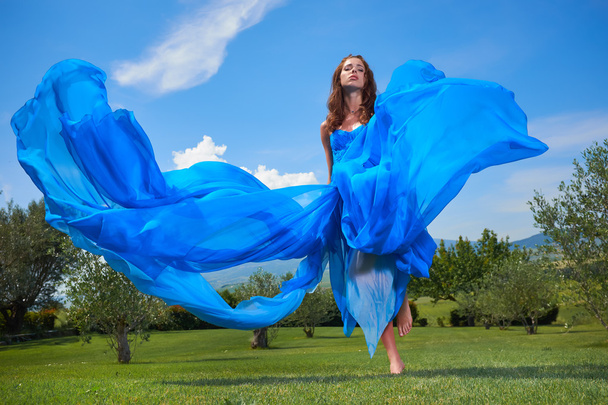 arka planda gökyüzü ile poz mavi elbiseli kadın - Fotoğraf, Görsel