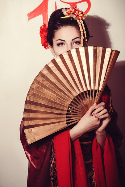 young pretty geisha in kimono with sakura and decoration - Foto, Imagen