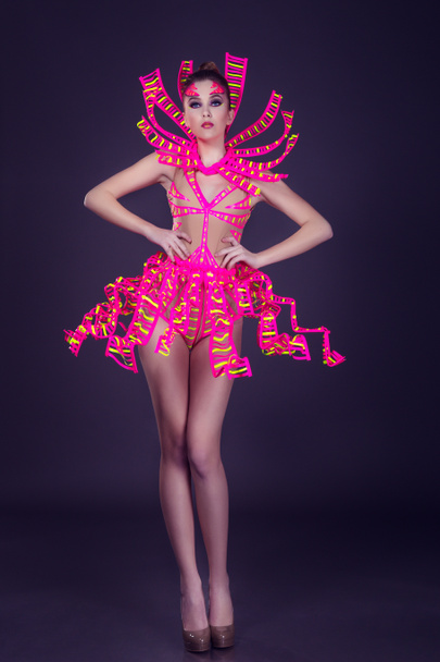 sexy female disco dancer poses in UV costume - Photo, Image