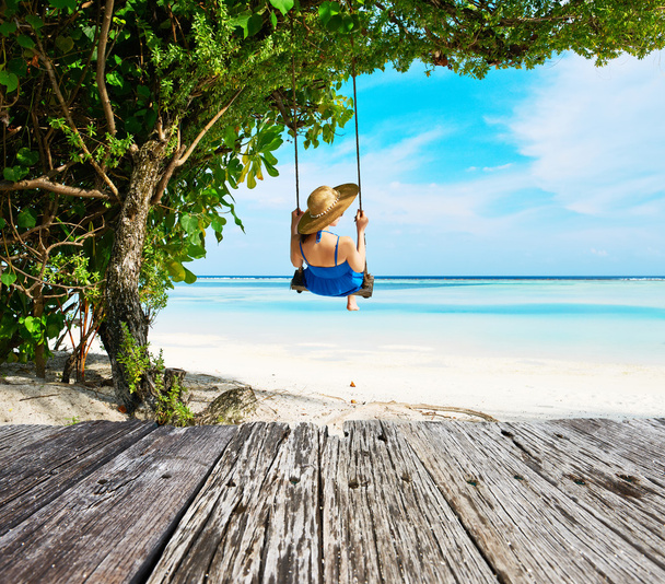 Femme en robe bleue balançant à la plage
 - Photo, image