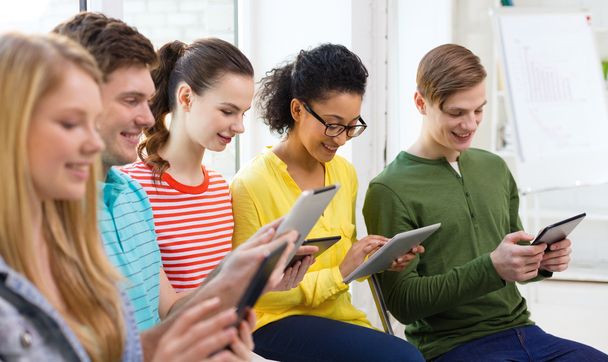 Estudiantes sonrientes con Tablet PC en la escuela
 - Foto, Imagen