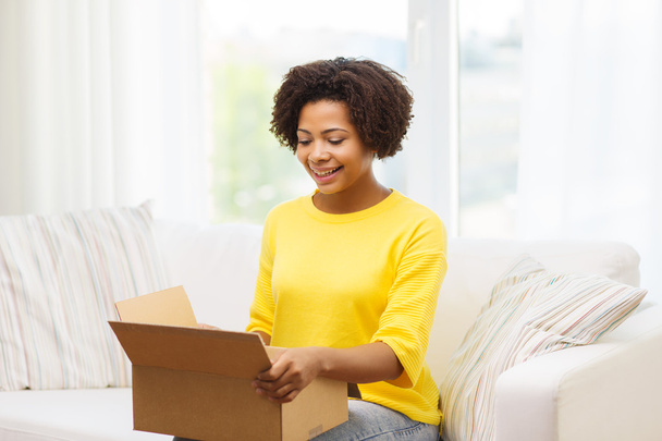 happy african young woman with parcel box at home - Foto, Imagem