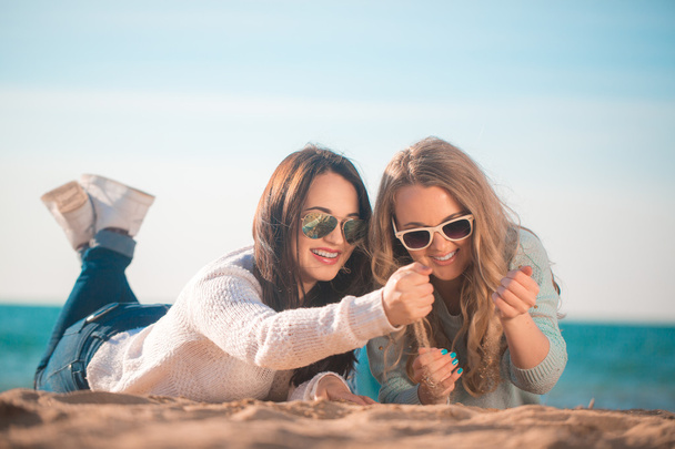 zwei Freundinnen ruhen sich am Strand aus - Foto, Bild