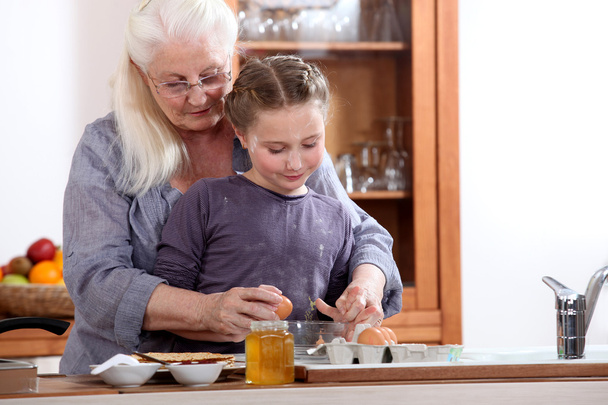 Little girl cooking with grandmother - Valokuva, kuva