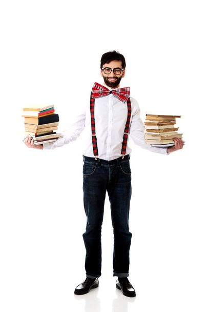 Man wearing suspenders with stack of books. - Foto, Imagem