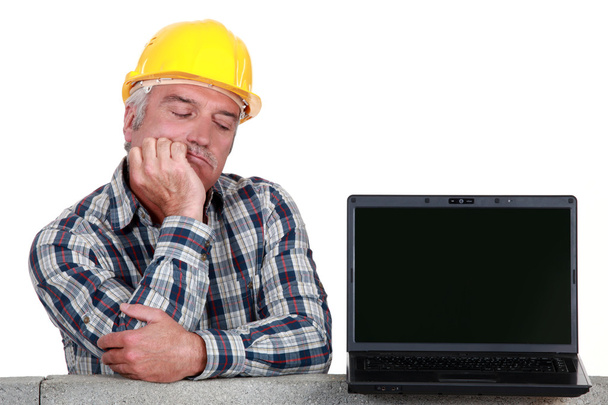 Senior craftsman posing next to a laptop - Photo, Image