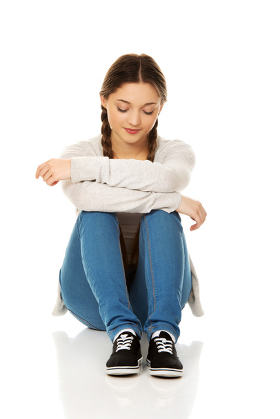 Depressed teen woman sitting. - Foto, afbeelding