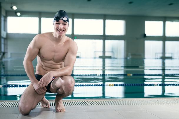 Young muscular swimmer with goggles and swim cap - Foto, imagen