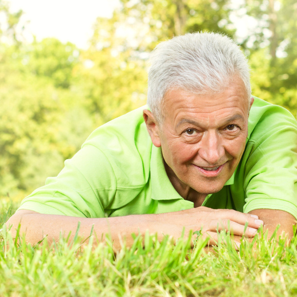 Портрет улыбающегося старика в парке
 - Фото, изображение