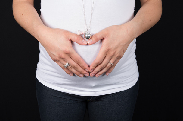 Portrait d'une femme enceinte heureuse au troisième trimestre isolé sur noir
 - Photo, image
