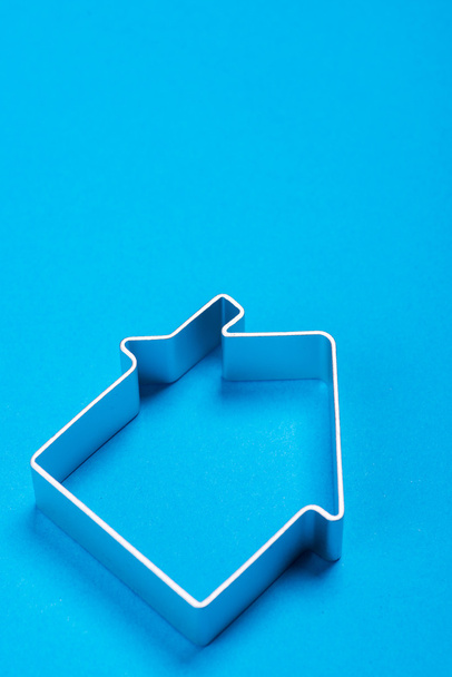 Casa in metallo in piedi su una superficie blu
 - Foto, immagini