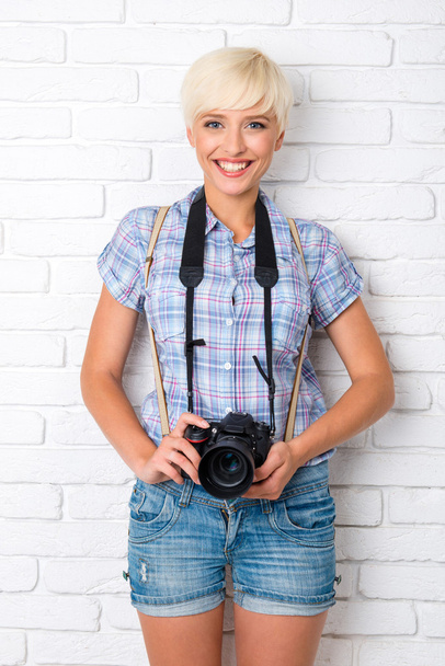 young woman with digital camera smiling  - 写真・画像