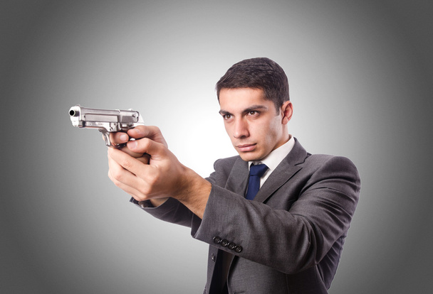 Businessman with gun against the gradient  - Фото, зображення