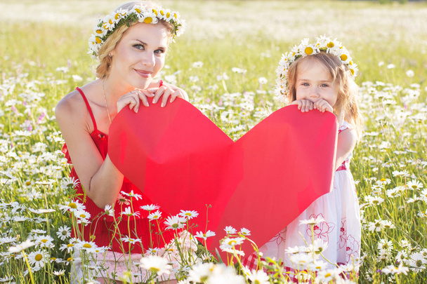 Mother and child are holding red heart - Photo, image