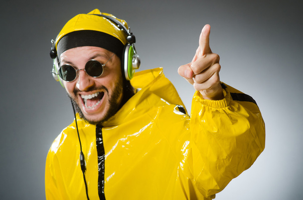 Άνθρωπος που φοράει κίτρινο κοστούμι ακούγοντας ακουστικά - Φωτογραφία, εικόνα