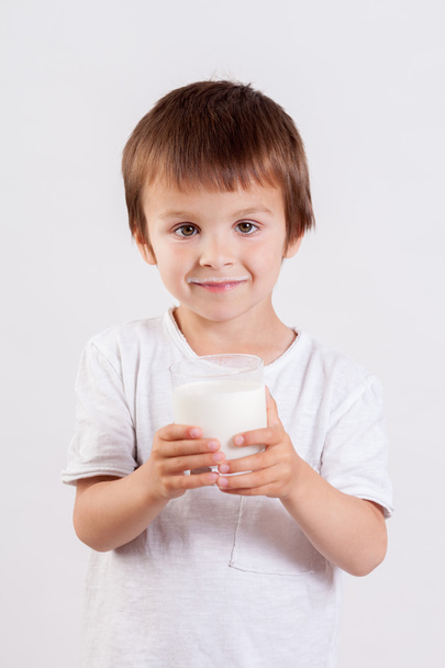 Cute little boy, drinking milk, holding glass of milk, mustaches - Foto, imagen