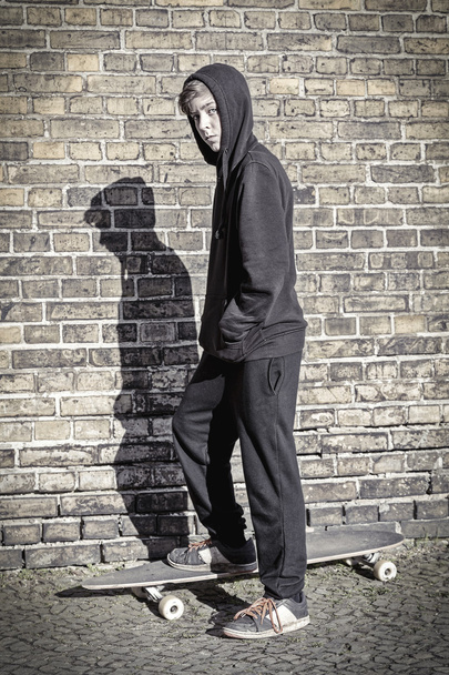 tiener met hoodie staande op een lange boord - Foto, afbeelding