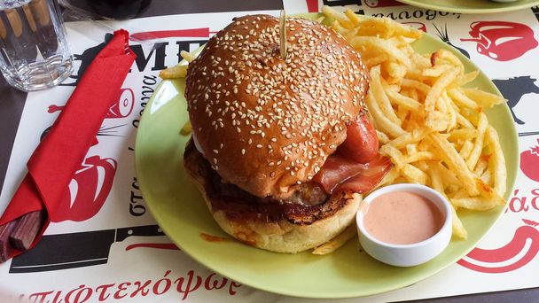 Величезний гамбургер зі смаженими помідорами та соусом
 - Фото, зображення