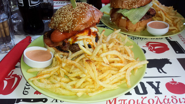 Величезний гамбургер зі смаженими помідорами та соусом
 - Фото, зображення