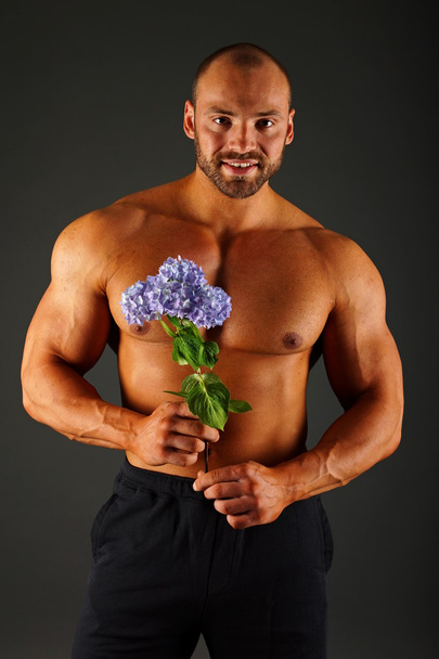 Portrait of muscular man with flower - Fotoğraf, Görsel