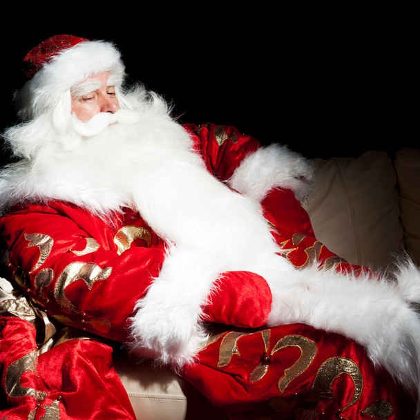 Santa sitting with a sack indoor at dark night room - Photo, Image