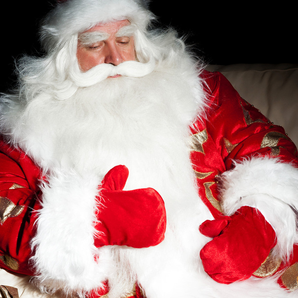 Santa sitting with a sack indoor at dark night room - Photo, image