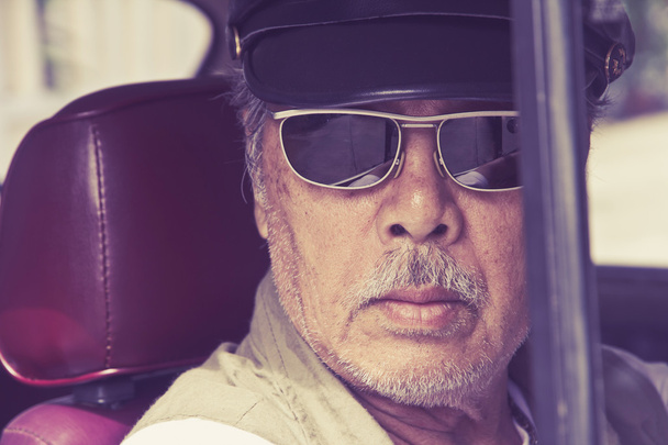 oudere man met bril besturen van een auto - Foto, afbeelding
