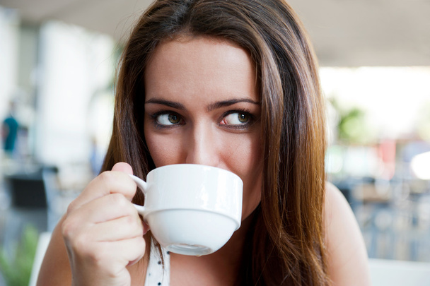 Retrato de cerca de una guapa joven tomando una taza de café
 - Foto, imagen
