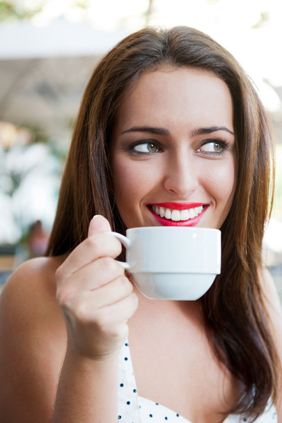 Closeup portrait of a pretty young female having a cup of coffee - 写真・画像