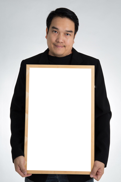 黒いスーツを着たアジア男を保持する空のホワイト ボード  - 写真・画像