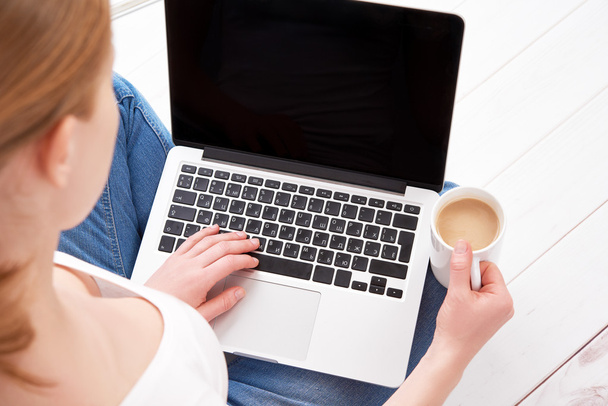 jeune femme heureuse se détend et travaille à la maison à un ordinateur portable avec
 - Photo, image