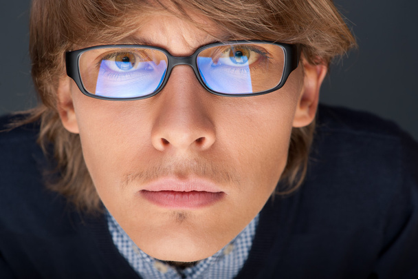 Satisfied young man with glasses looking at camera like at lapto - 写真・画像
