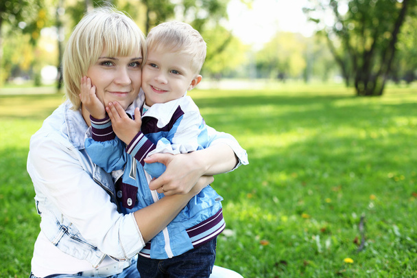 Young mother with her son in summer park - Фото, зображення