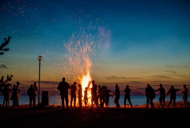 Les gens se reposent près de grand feu de joie extérieur
 - Photo, image