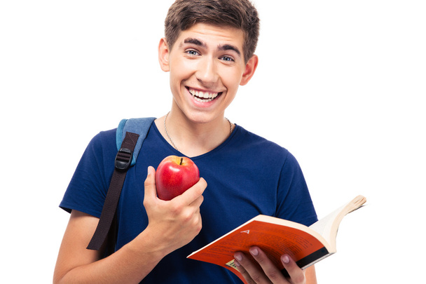 Smiling male student holding apple and book - Фото, зображення