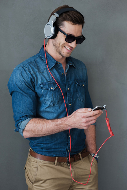 man in headphones holding MP3 player - Foto, Imagen