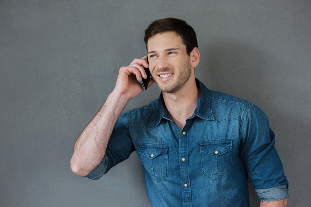Cheerful young man talking on mobile phone - Foto, afbeelding