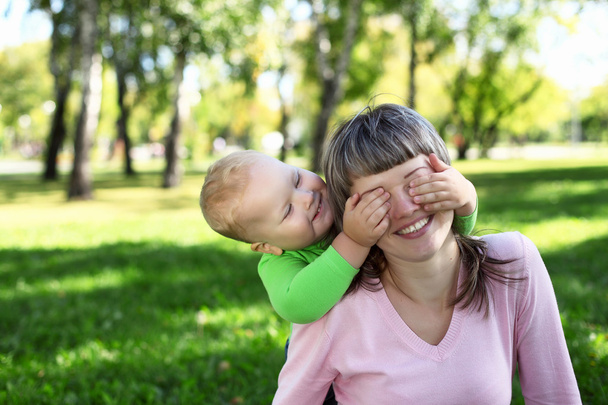 Young mother with her son in summer park - Foto, afbeelding