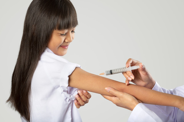 Доктор вакцинирует маленькую девочку
 - Фото, изображение