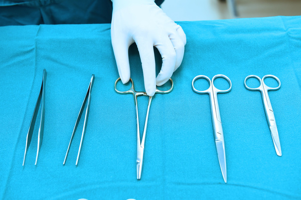 Detail shot of steralized surgery instruments with a hand grabbing a tool - Foto, Imagen