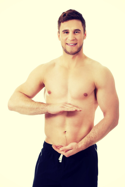 Sexy muscular man holding copyspace in hands. - Foto, Imagen