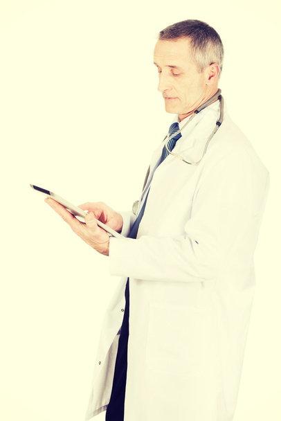 Mature male doctor using a tablet - Photo, Image