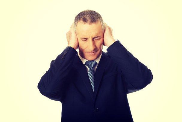 Hombre de negocios cansado cubriendo oídos con las manos
 - Foto, Imagen