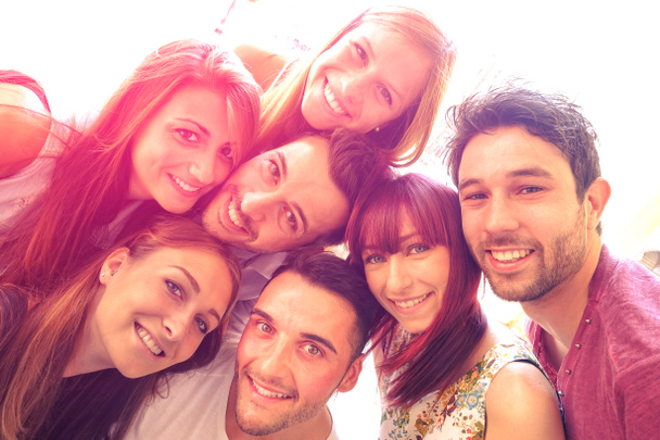 beste vrienden nemen selfie buiten met achtergrondverlichting contrast - gelukkig vriendschap concept met jongeren plezier samen - vintage gefilterde look met marsala kleurtinten en zonneschijn halo flare - Foto, afbeelding